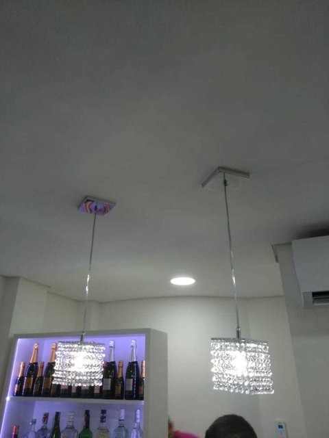 Pendentes de cristal Kira iluminando um ambiente moderno com prateleira de bebidas ao fundo. Lustres Gênesis loja online de Lustres e Iluminação Decorativa